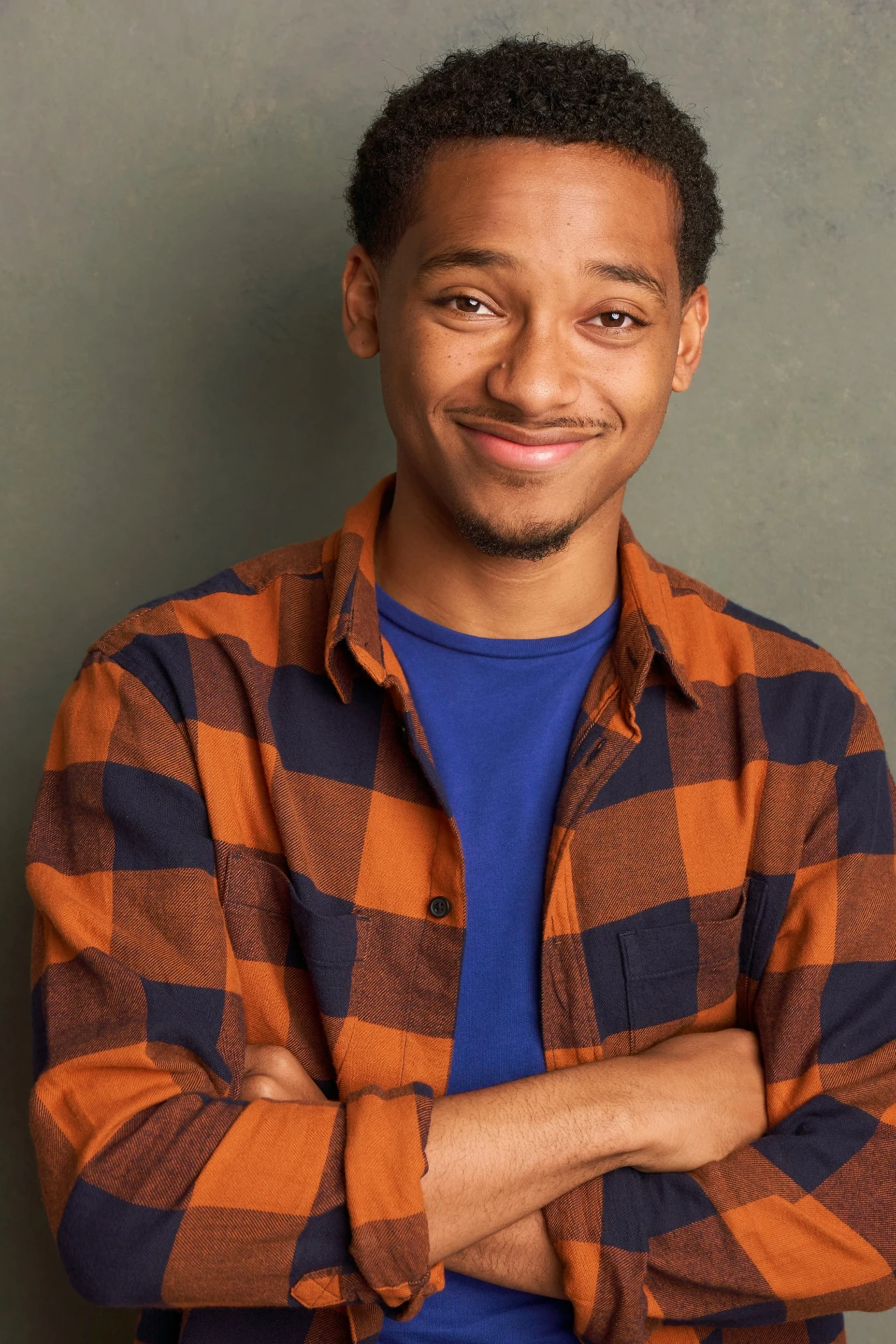 Editorial actor headshot of smiling actor in an orange plaid shirt, photographed by an Atlanta actor headshot photographer