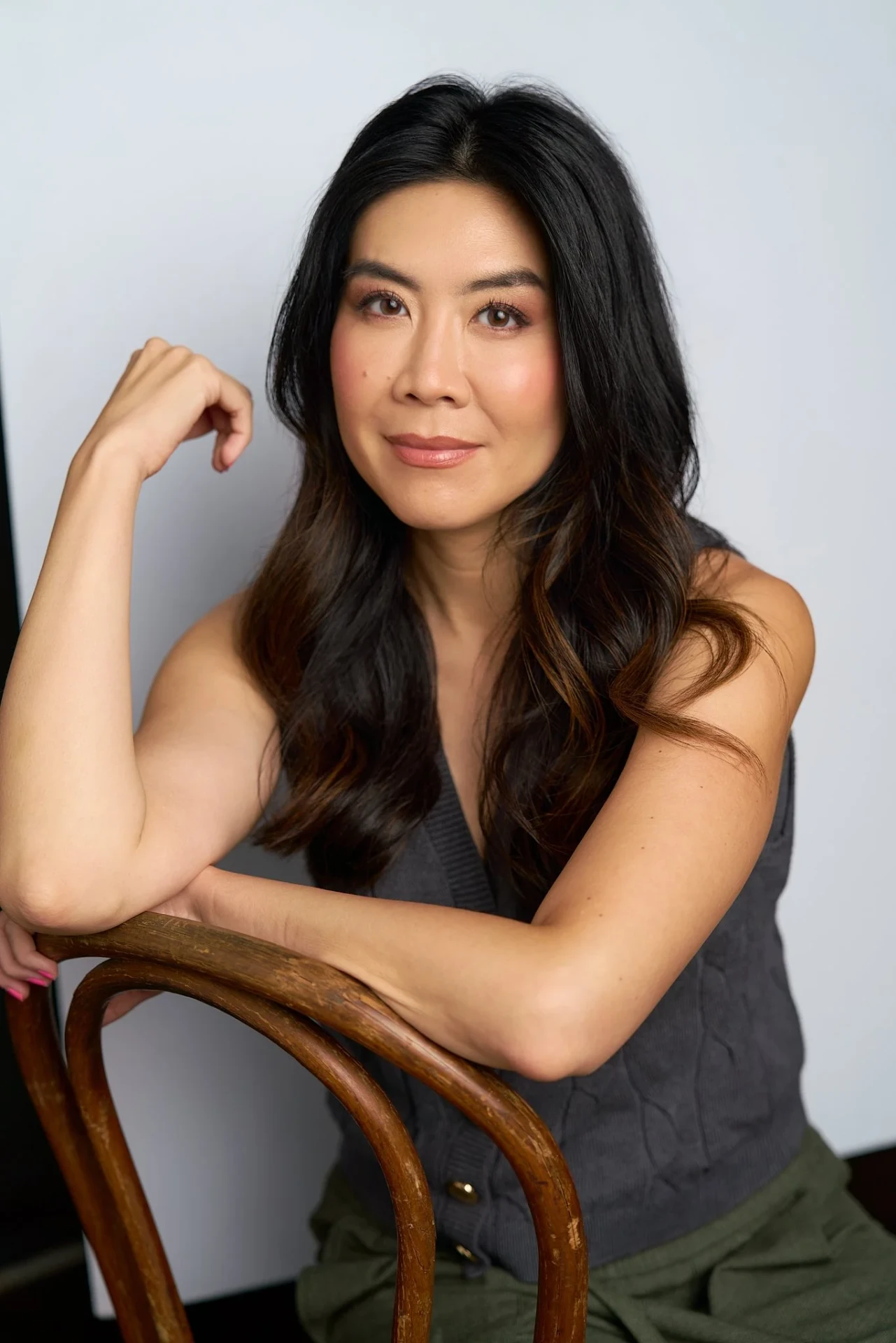 Seated actress headshot leaning on a wooden chair at an Atlanta studio