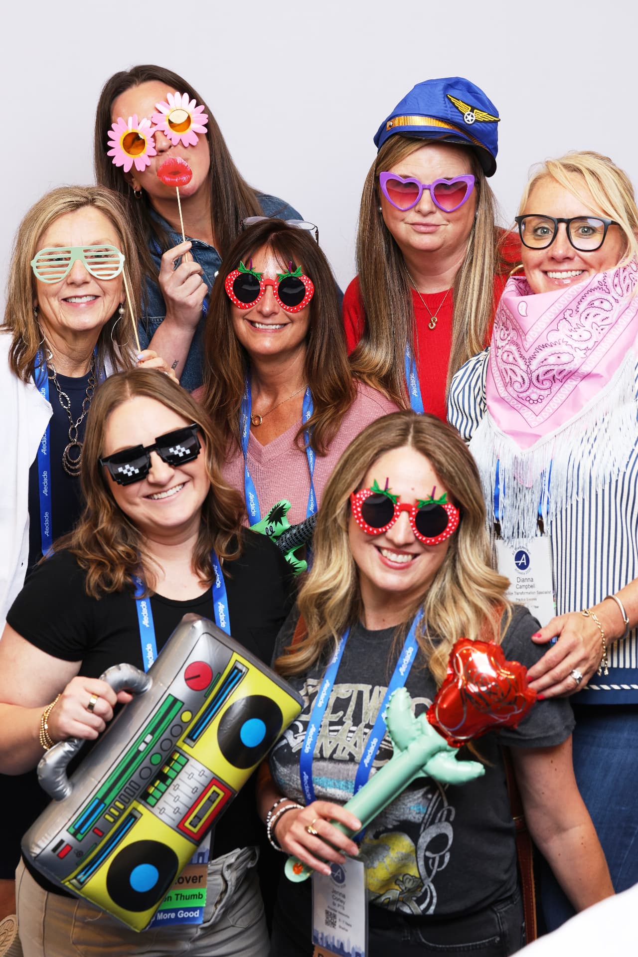 Seven Aledade attendees holding an inflatable boombox and rose at an Atlanta event photobooth