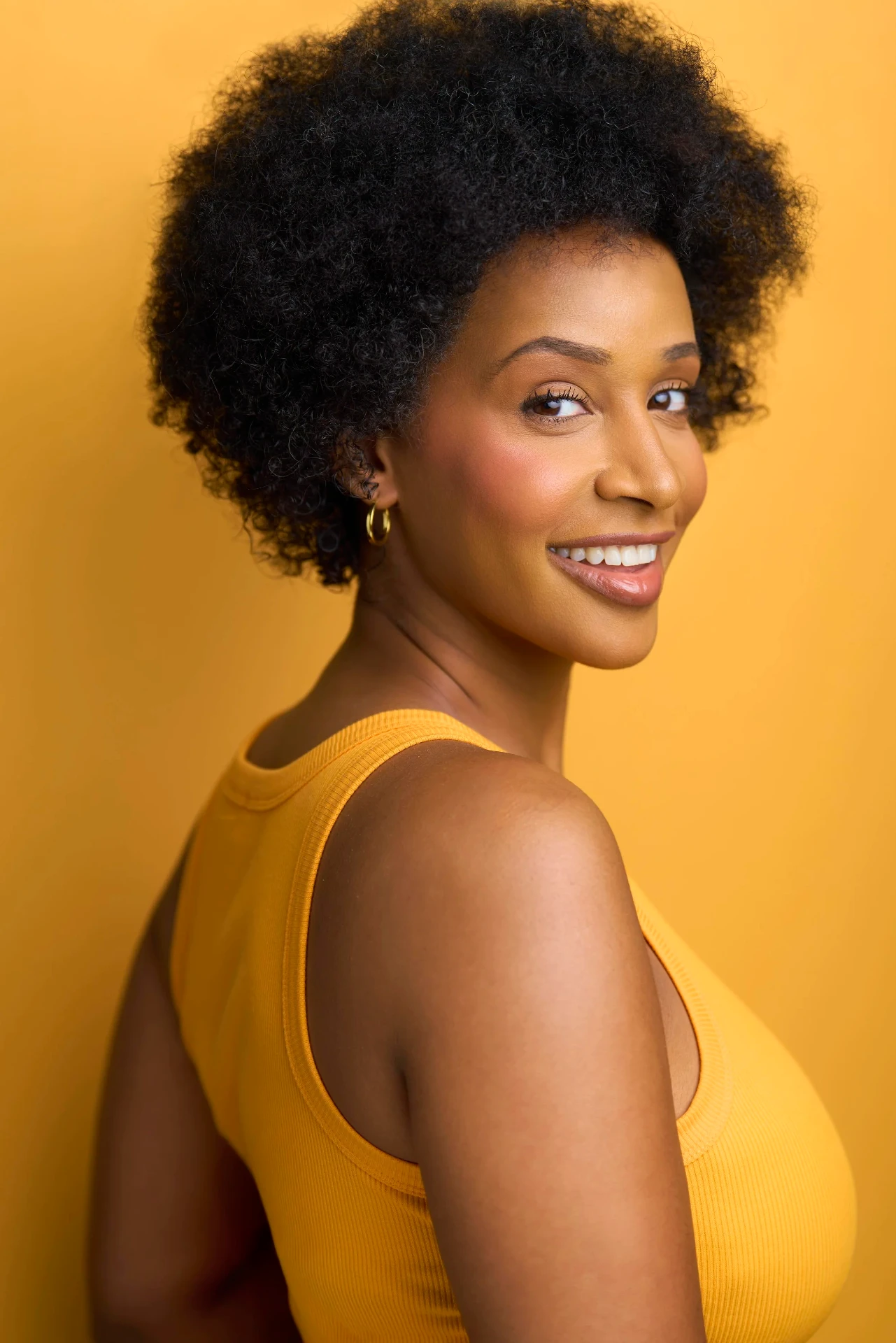Commercial actress headshot in yellow on a golden backdrop in Atlanta