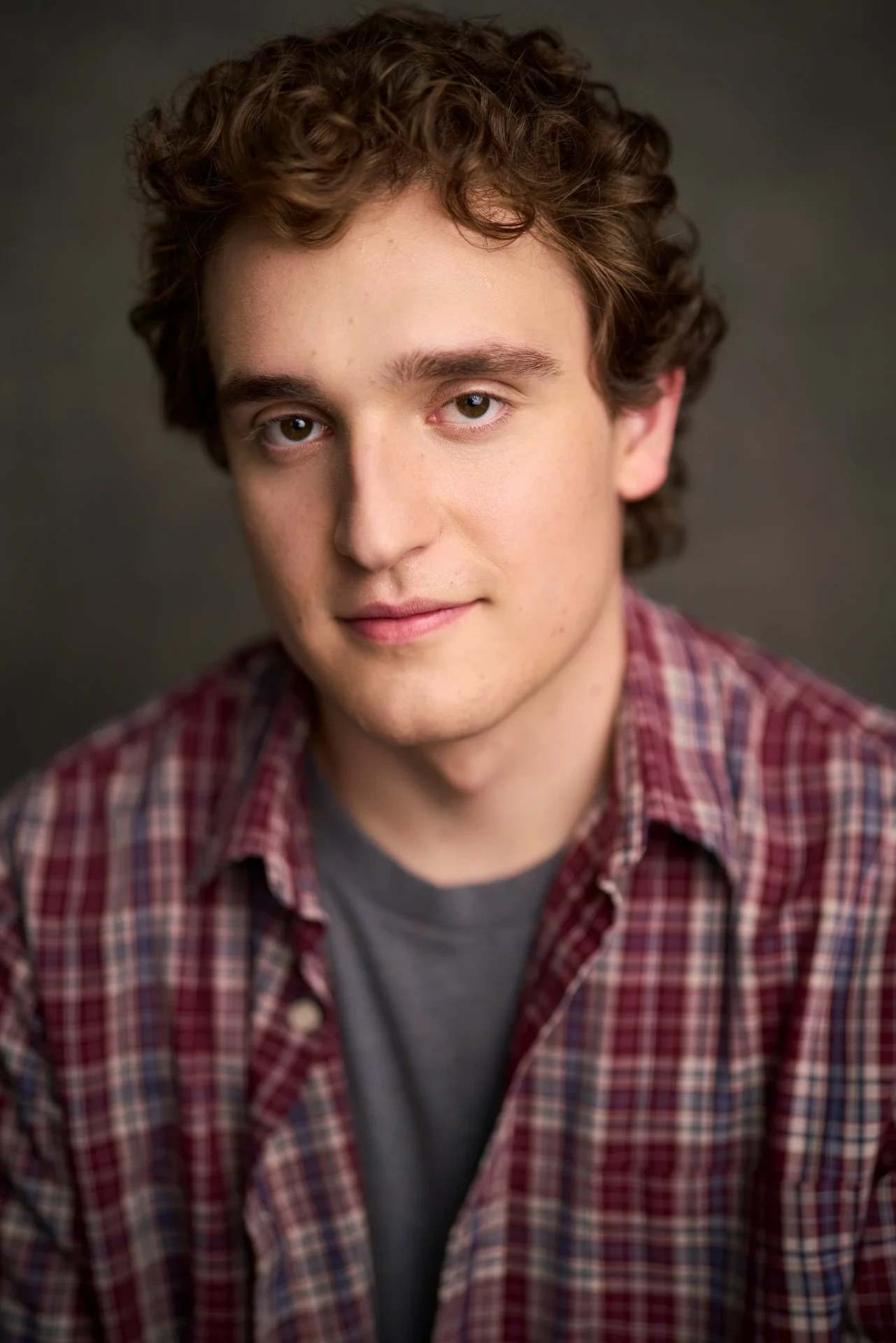 Editorial actor headshot of curly-haired actor in a plaid shirt, photographed by an Atlanta actor headshot photographer