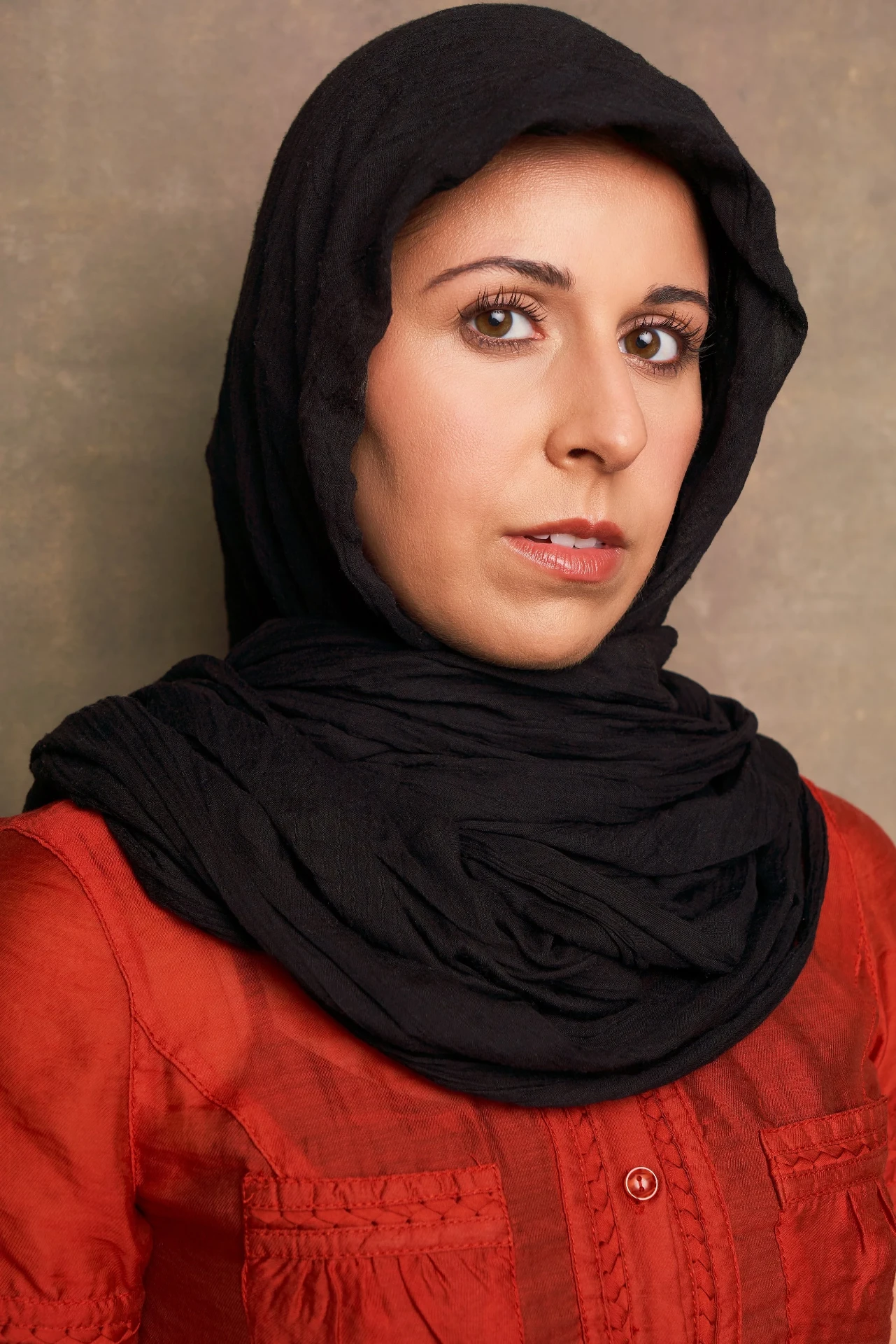 Editorial actor headshot of actress in a black hijab and red top, photographed by an Atlanta actor headshot photographer