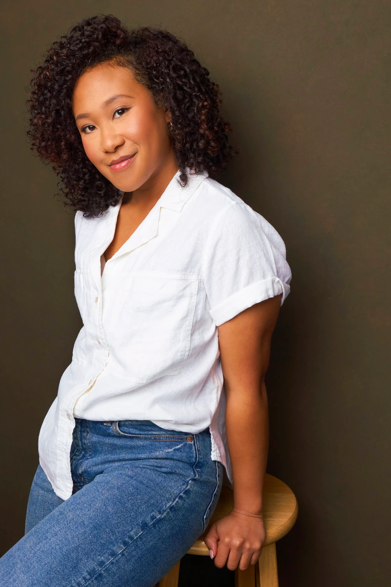 Editorial actor headshot of actress in a white shirt seated on a stool, photographed by an Atlanta actor headshot photographer