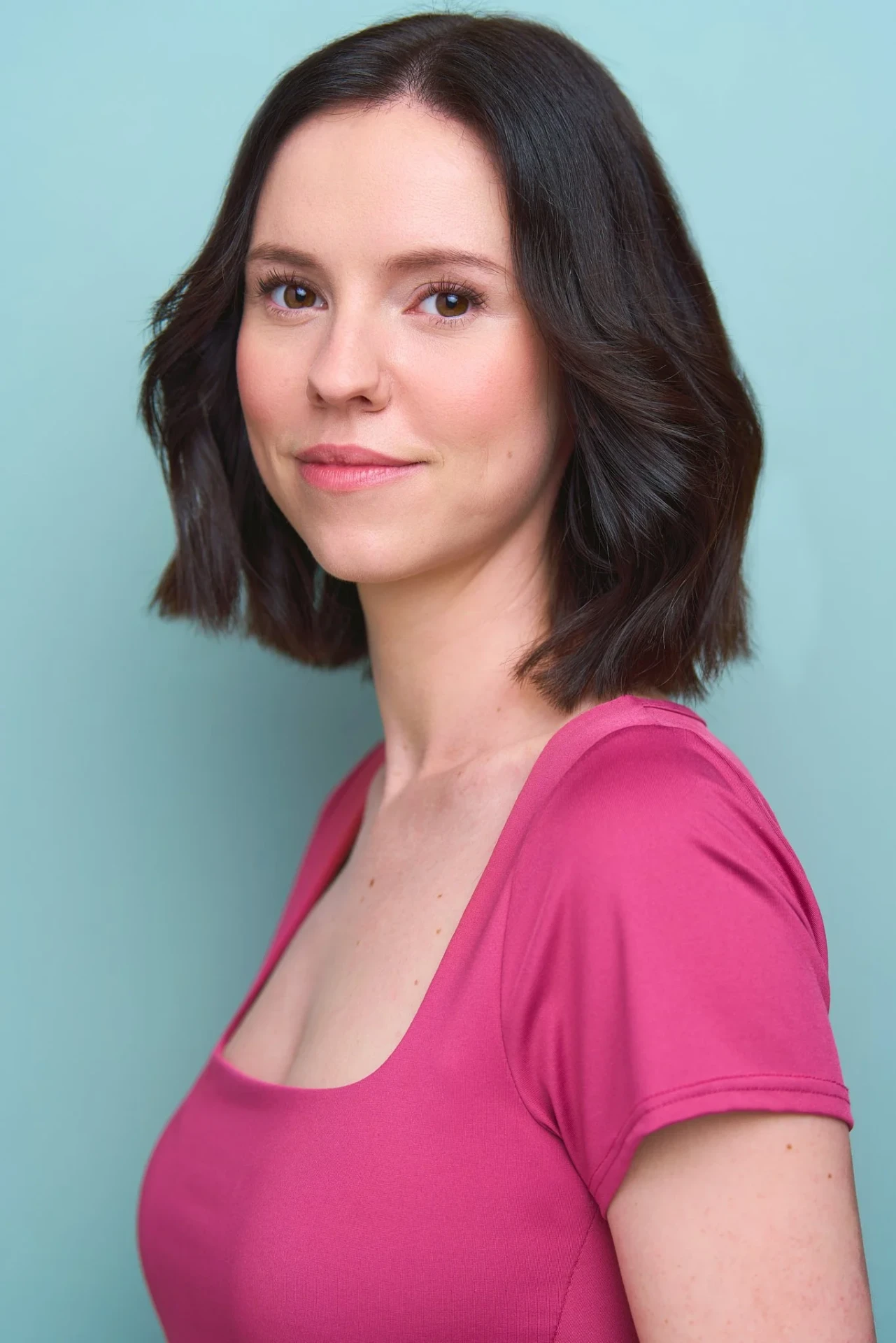 Commercial actress headshot in pink on a mint backdrop in Atlanta