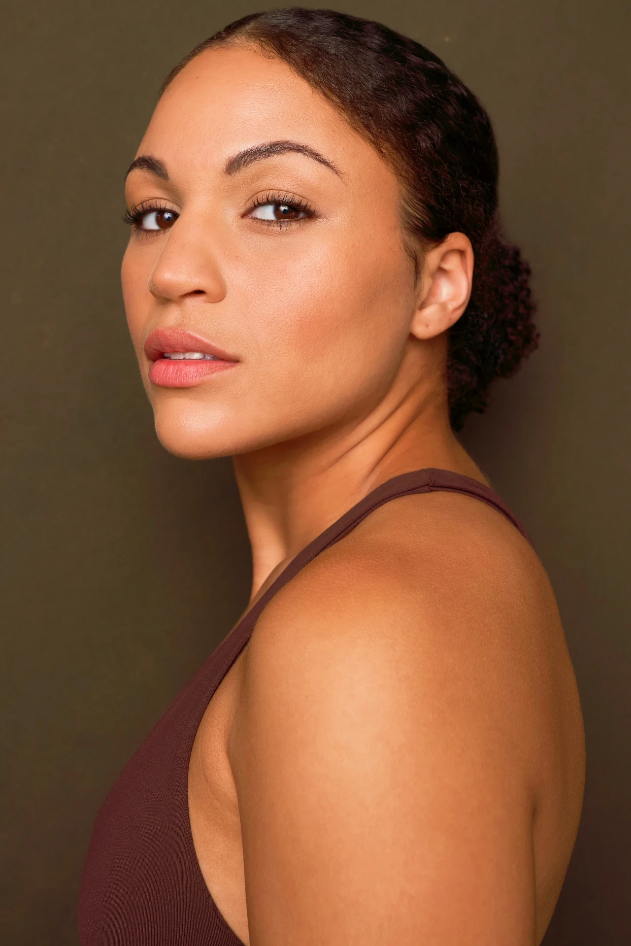Editorial actor headshot of actress in profile on a warm brown backdrop, photographed by an Atlanta actor headshot photographer