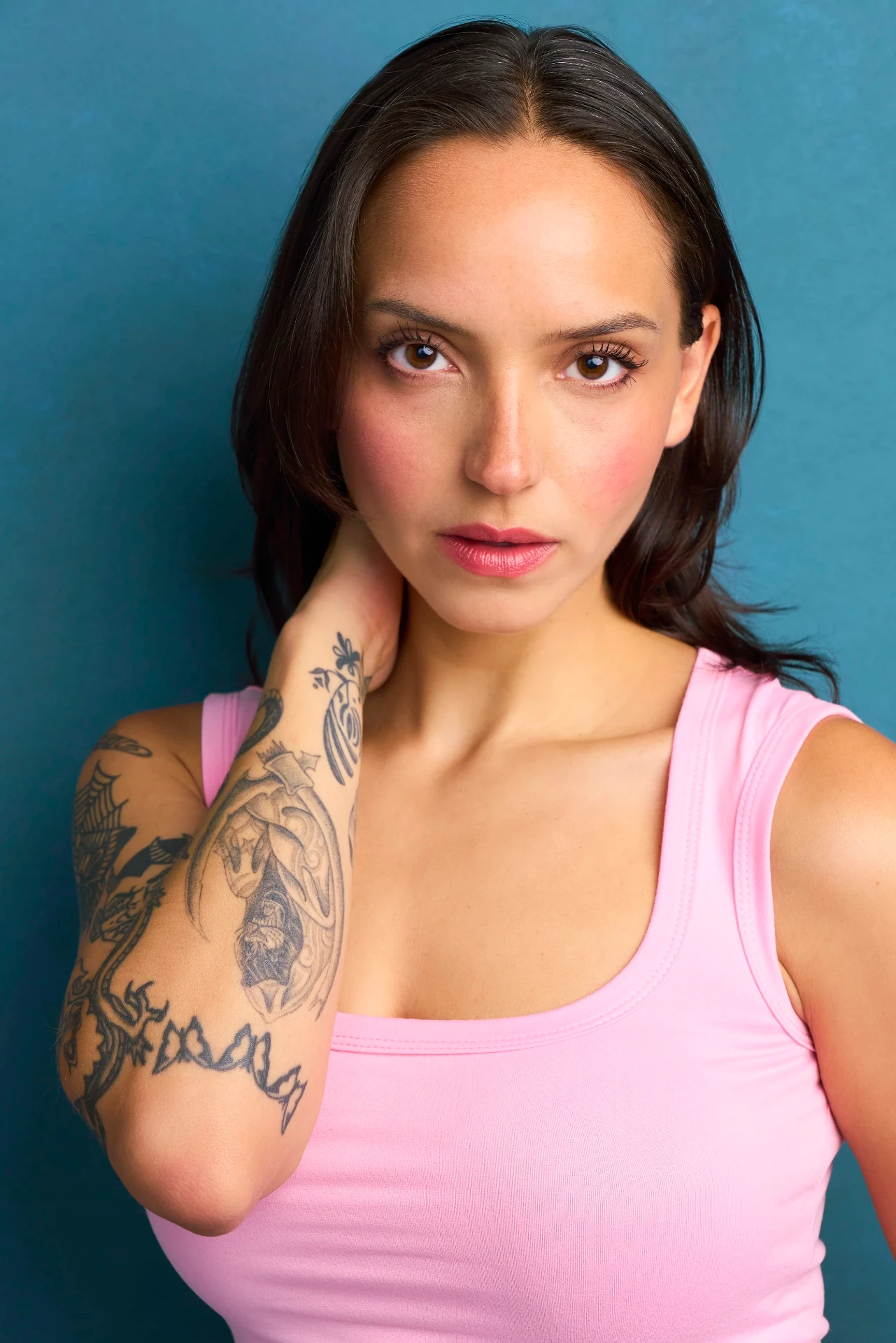 Theatrical actress headshot in a pink top on a teal backdrop in Atlanta