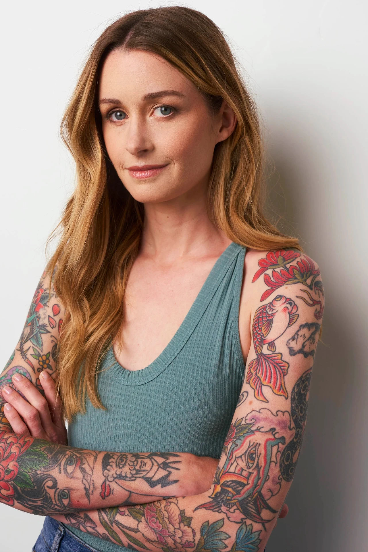 Editorial actor headshot of tattooed actress in a sage tank with arms crossed, photographed by an Atlanta actor headshot photographer