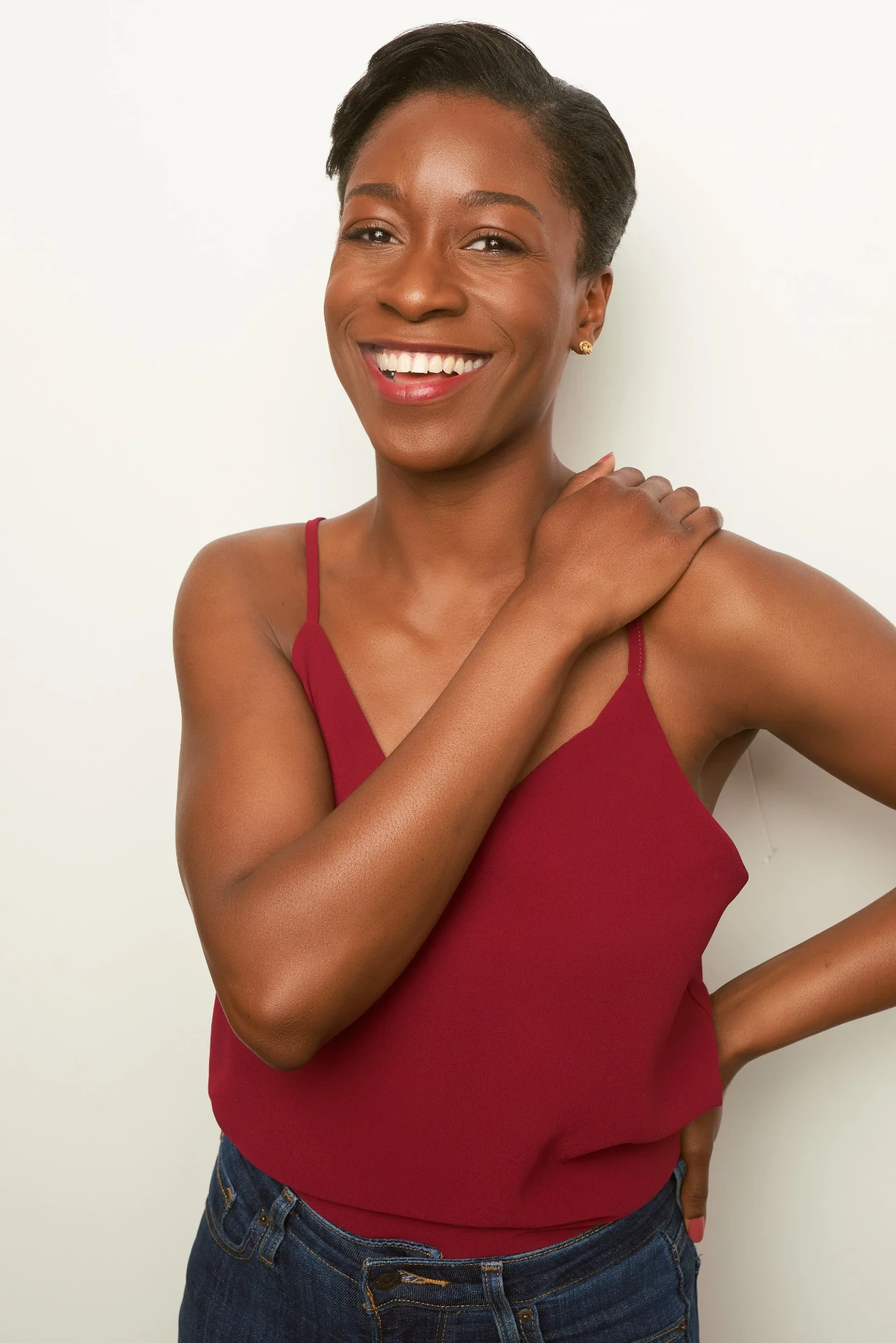 Playful actress headshot in a red cami on a white backdrop in Atlanta