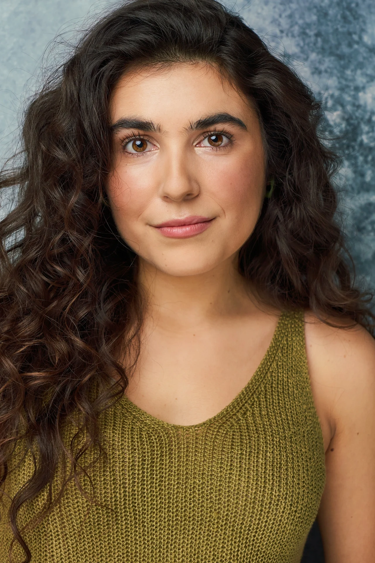 Editorial actor headshot of actress in an olive knit tank on a textured backdrop, photographed by an Atlanta actor headshot photographer