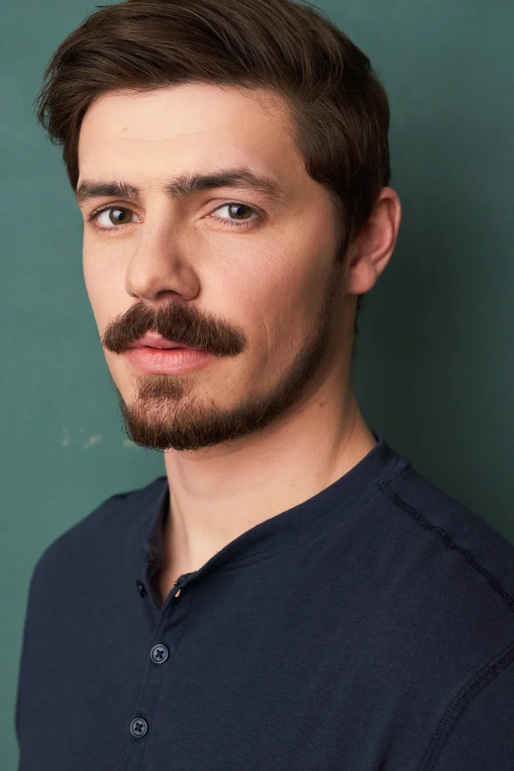 Theatrical male actor headshot on a green backdrop by an Atlanta actor headshot photographer