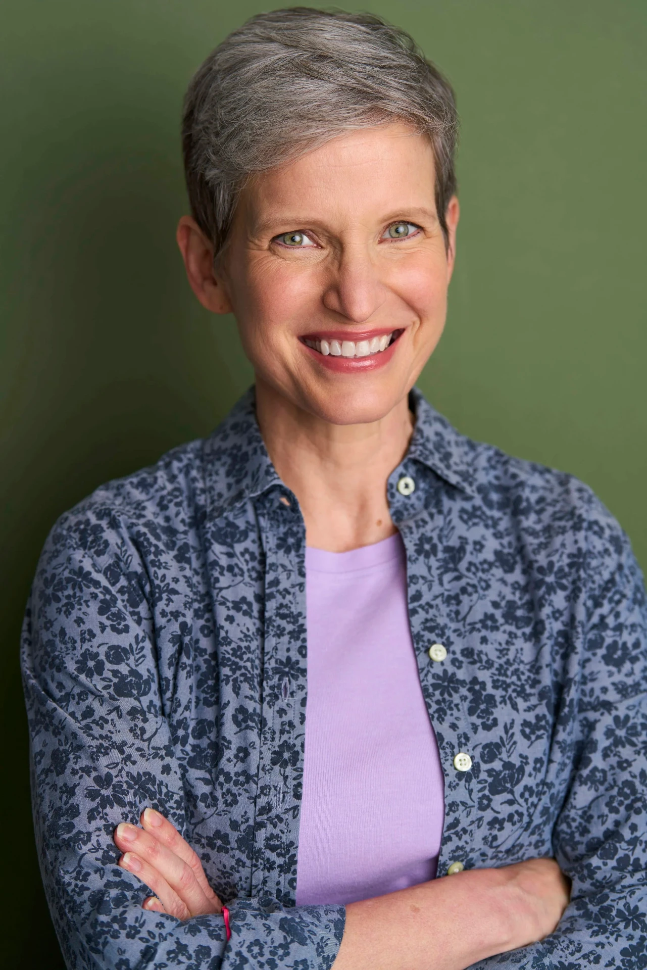 Editorial actor headshot of smiling actress in a floral shirt on a green backdrop, photographed by an Atlanta actor headshot photographer