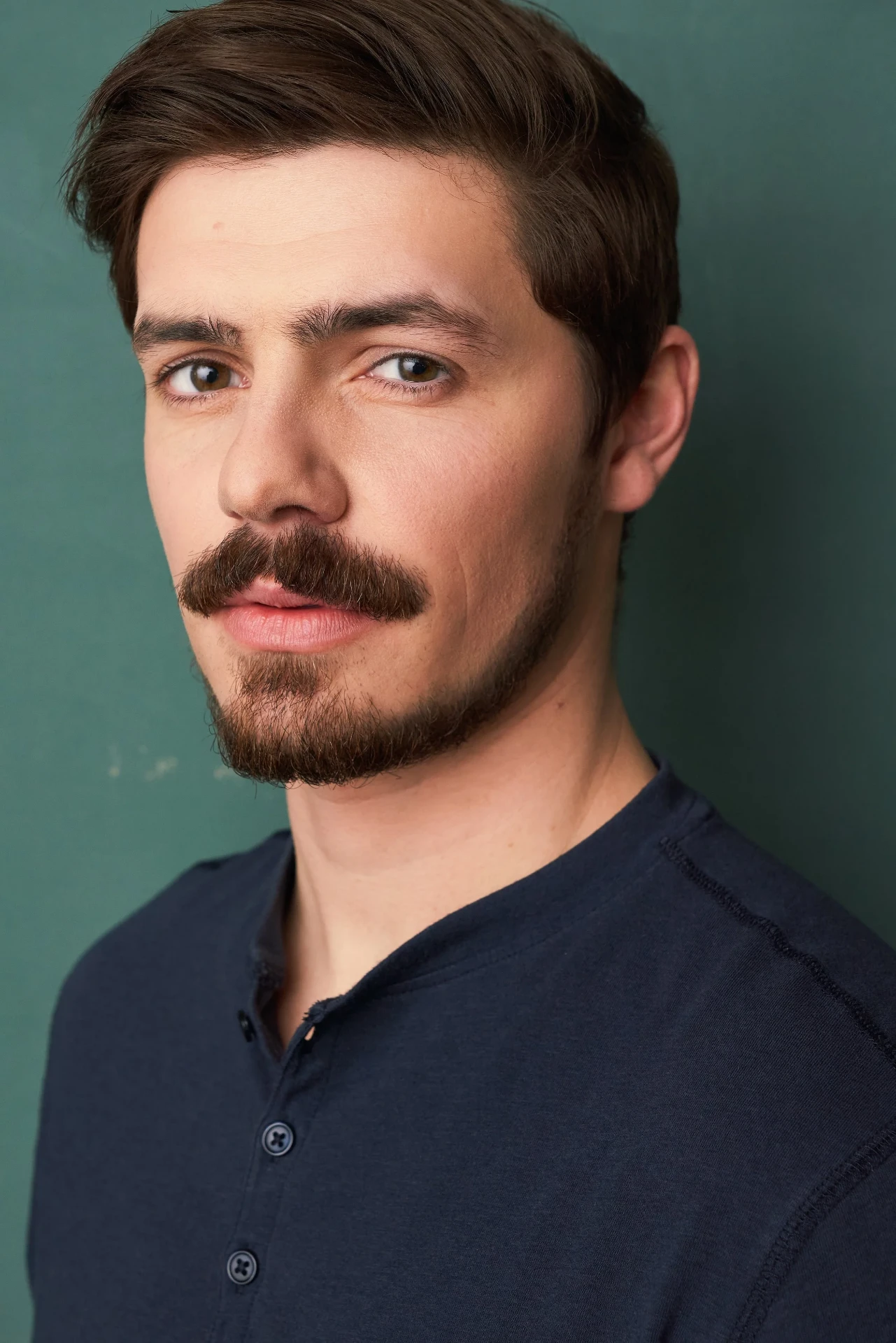 Editorial actor headshot of mustached actor in a navy henley, photographed by an Atlanta actor headshot photographer