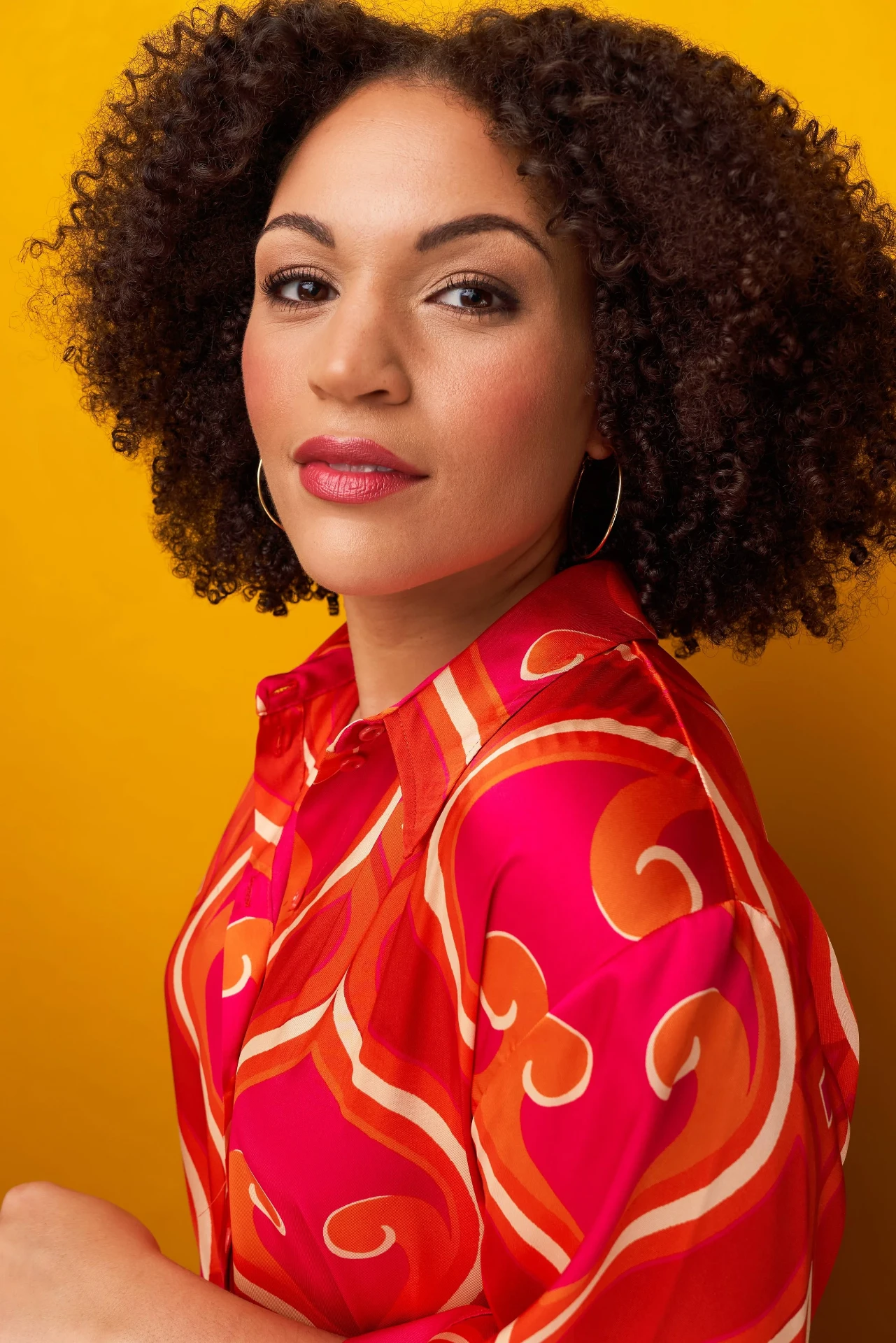 Editorial actor headshot of actress in a red print shirt on a yellow backdrop, photographed by an Atlanta actor headshot photographer