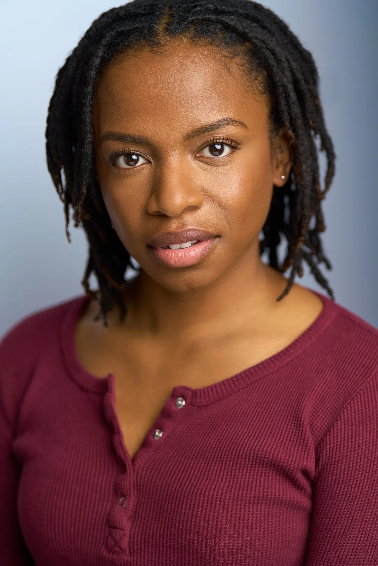 Dramatic actress headshot with locs in a red henley photographed in Atlanta