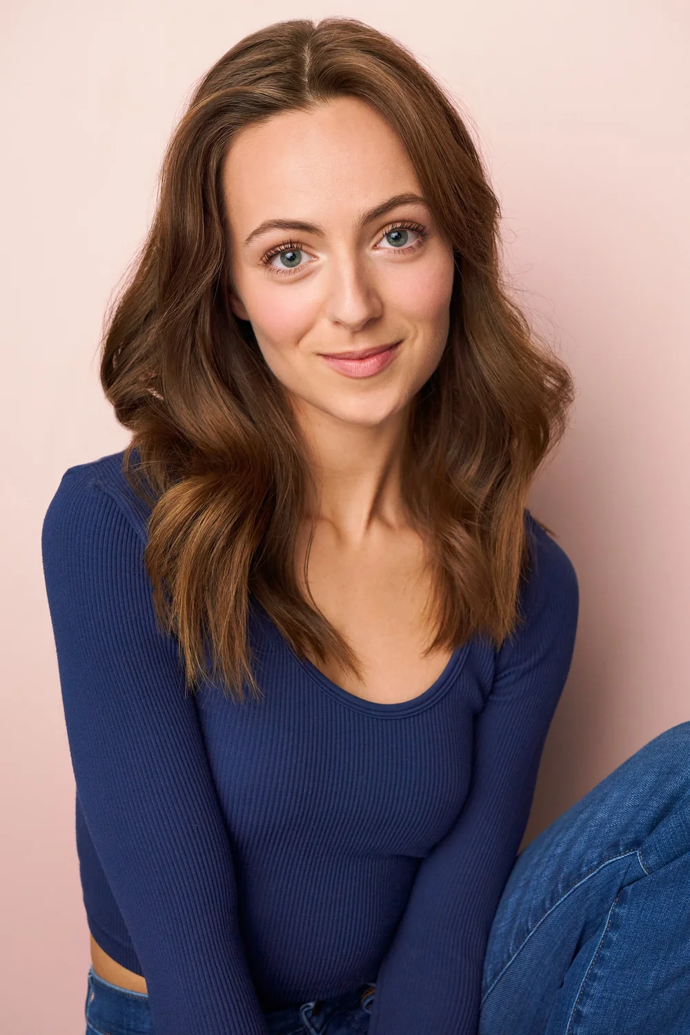 Atlanta actress headshot in a blue top against a soft pink studio backdrop